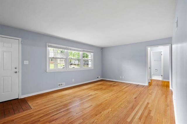 unfurnished living room featuring light wood-type flooring and baseboards