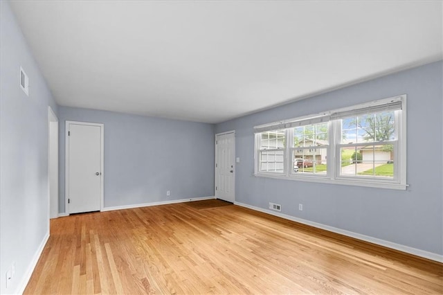 empty room with light wood-style flooring and baseboards