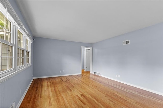 unfurnished room with light wood-style flooring and baseboards