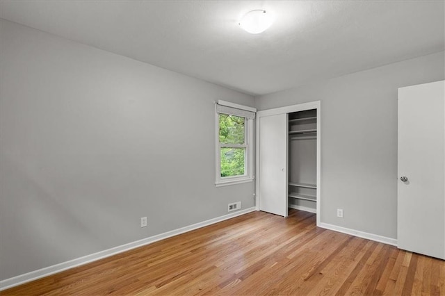 unfurnished bedroom with light wood-style floors, a closet, and baseboards