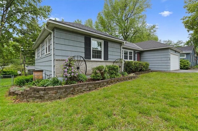 ranch-style house featuring a garage and driveway