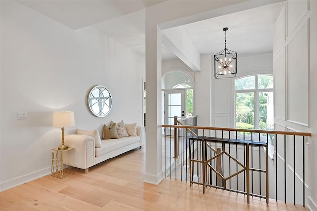 17045 S Highland Ridge Dr, Loch Lloyd, MO 64012 - living area featuring an upstairs landing, a chandelier, light wood-style flooring, and baseboards