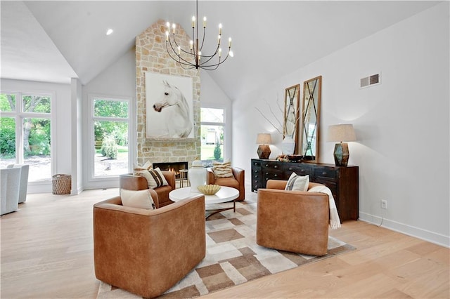 17045 S Highland Ridge Dr, Loch Lloyd, MO 64012 - living area featuring wood finished floors, a chandelier, a stone fireplace, high vaulted ceiling, and baseboards