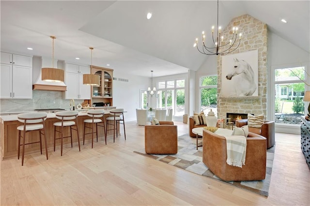 17045 S Highland Ridge Dr, Loch Lloyd, MO 64012 - living area featuring a chandelier, light wood-style floors, healthy amount of natural light, high vaulted ceiling, and a fireplace
