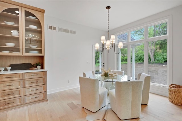 17045 S Highland Ridge Dr, Loch Lloyd, MO 64012 - dining area with a chandelier, light wood-style floors, and baseboards