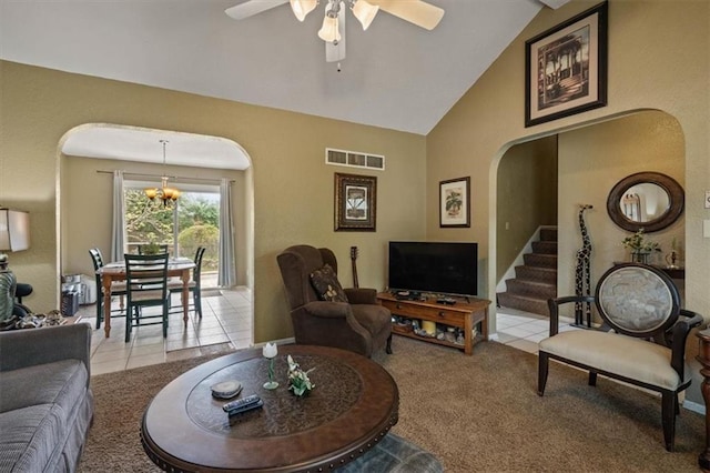 living room with light colored carpet, arched walkways, ceiling fan with notable chandelier, and visible vents