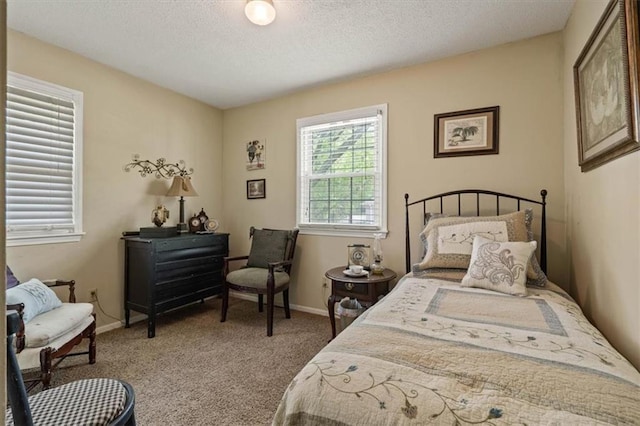 carpeted bedroom featuring baseboards and a textured ceiling