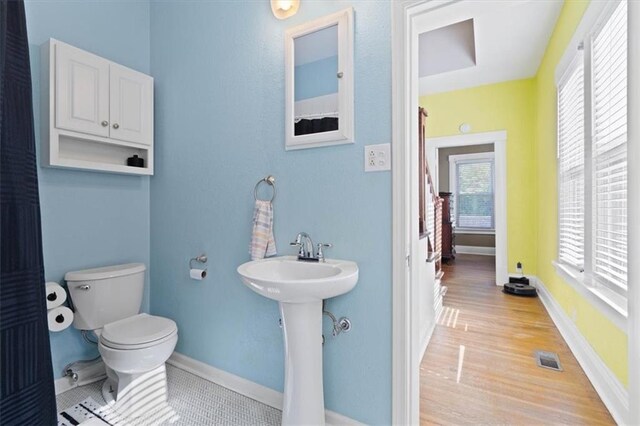 2717 Faraon St, Saint Joseph, MO 64501 - bathroom featuring toilet, baseboards, wood finished floors, and a sink