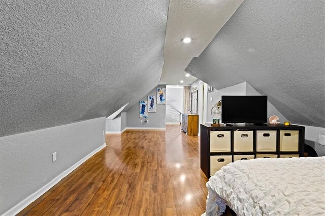 2717 Faraon St, Saint Joseph, MO 64501 - bedroom with a textured ceiling, baseboards, wood finished floors, and vaulted ceiling