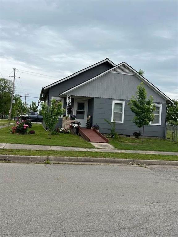 bungalow-style home featuring a front lawn and crawl space
