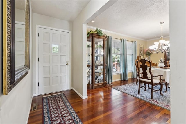 2106 Kasold Dr, Lawrence, KS 66047 - entrance foyer featuring visible vents, wood finished floors, baseboards, a notable chandelier, and ornamental molding