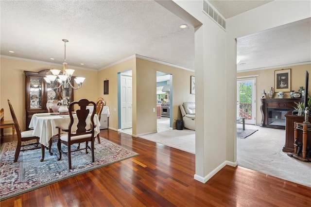 2106 Kasold Dr, Lawrence, KS 66047 - dining area featuring a textured ceiling, visible vents, wood finished floors, baseboards, and a chandelier
