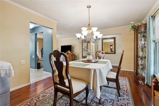 2106 Kasold Dr, Lawrence, KS 66047 - dining room with baseboards, crown molding, wood finished floors, and a chandelier