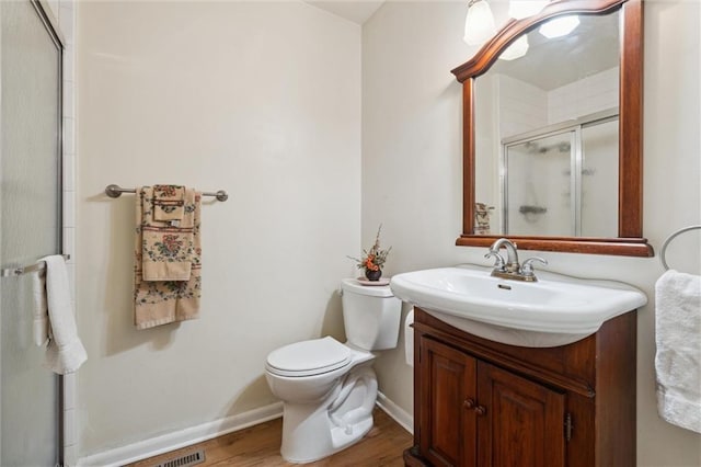 2106 Kasold Dr, Lawrence, KS 66047 - bathroom with vanity, toilet, baseboards, a shower stall, and wood finished floors