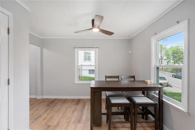 dining area featuring a ceiling fan, baseboards, light wood-style flooring, and crown molding