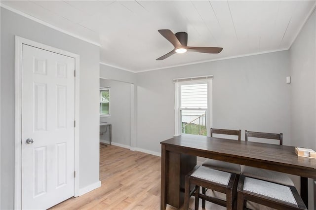 dining area featuring ceiling fan, light wood-style flooring, baseboards, and ornamental molding