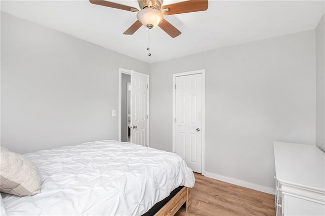 bedroom featuring ceiling fan, baseboards, and light wood-style floors
