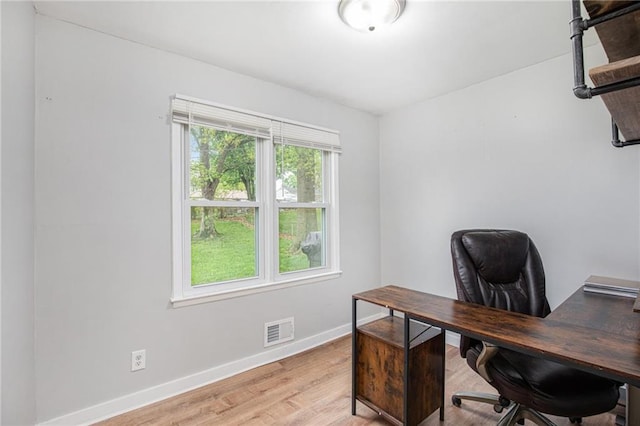 office with baseboards, light wood-type flooring, and visible vents