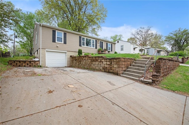 ranch-style home featuring stairway, an attached garage, and driveway