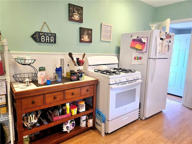 kitchen with light wood-style floors and white appliances