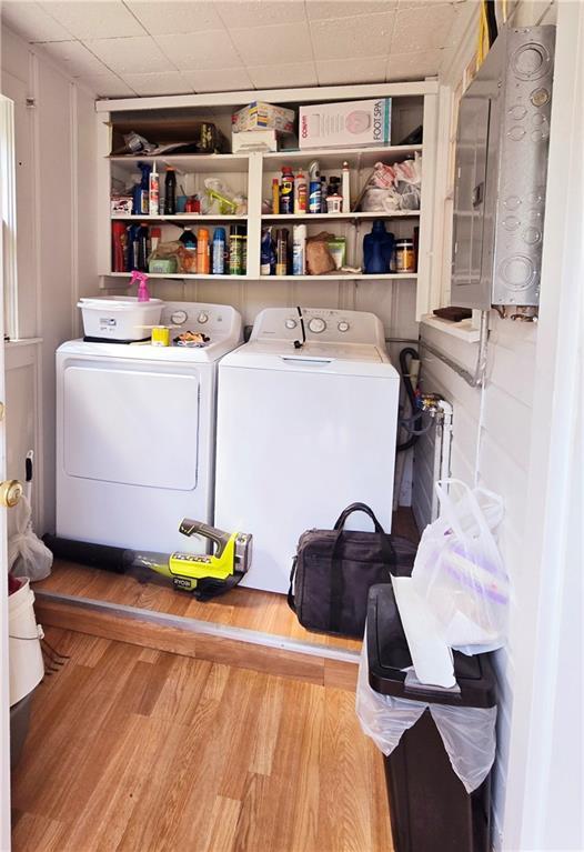 laundry room with laundry area, wood finished floors, and washer and clothes dryer