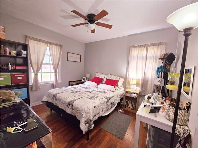 bedroom featuring baseboards, ceiling fan, and wood finished floors