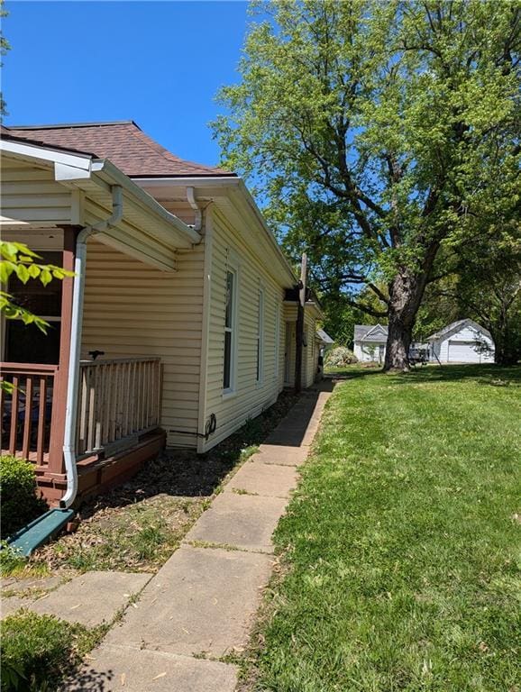 100 E 11th St, Horton, KS 66439 - view of side of property featuring a lawn and roof with shingles