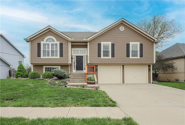 split foyer home featuring a garage, a front yard, and concrete driveway