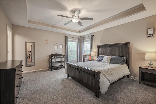 bedroom with a tray ceiling, carpet, baseboards, and ceiling fan