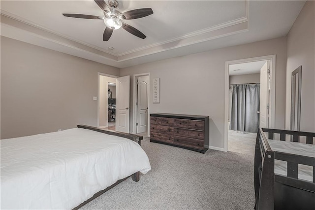 carpeted bedroom featuring crown molding, a tray ceiling, a ceiling fan, and baseboards