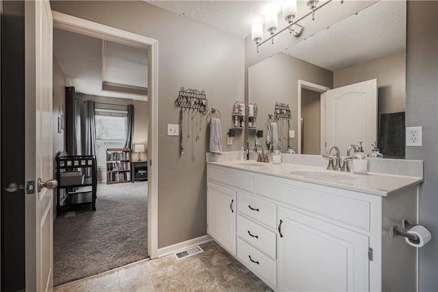 full bathroom featuring double vanity, a textured ceiling, and baseboards