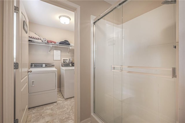 clothes washing area with washer and dryer and baseboards