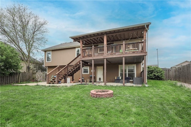 back of property with a fire pit, stairway, a deck, and a patio