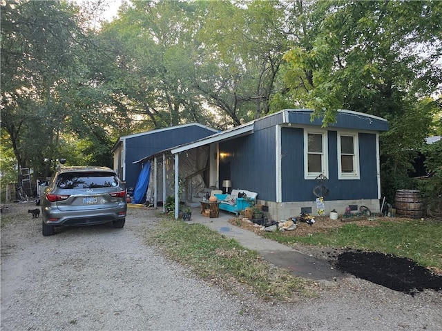 view of front of property with gravel driveway and crawl space