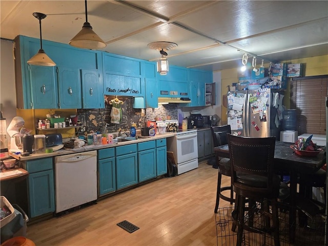 kitchen with light wood finished floors, white appliances, blue cabinetry, under cabinet range hood, and visible vents