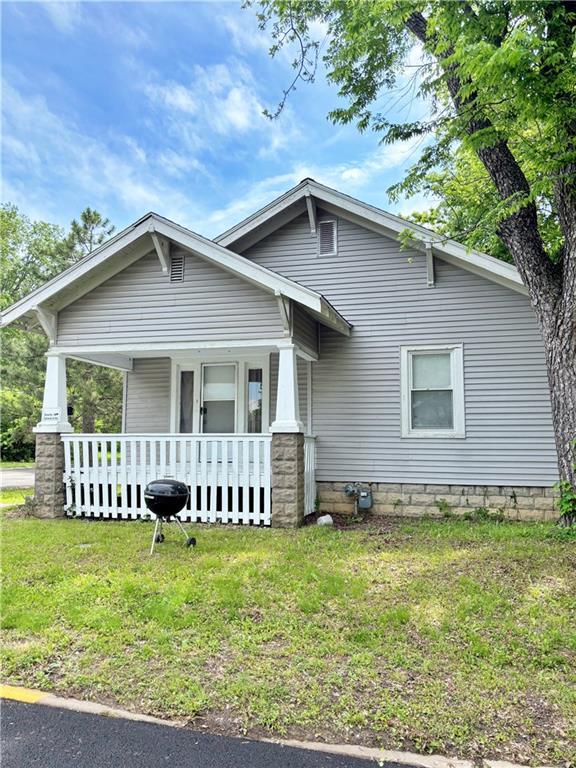 view of front of house with a front yard and a porch