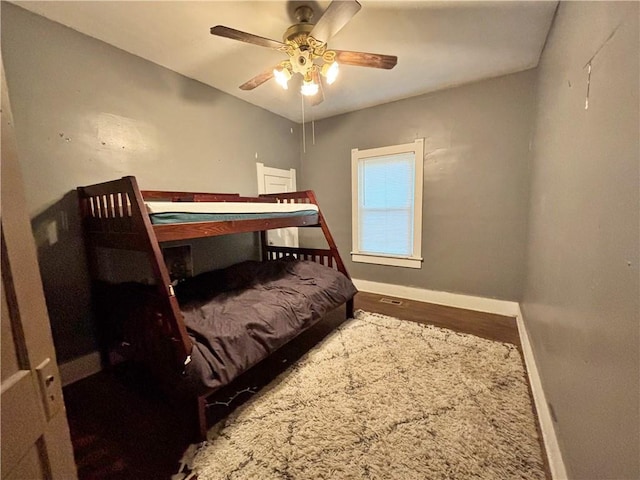 bedroom with baseboards, a ceiling fan, and wood finished floors
