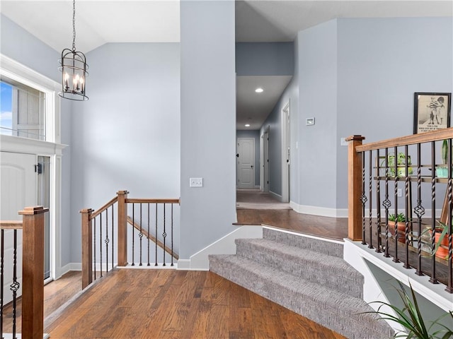 5084 NW Timberline Dr, Riverside, MO 64150 - stairs with a notable chandelier, wood finished floors, baseboards, lofted ceiling, and recessed lighting