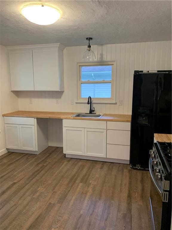 308 NW Shamrock Ave, Lees Summit, MO 64081 - kitchen with a sink, wooden counters, stainless steel range with gas cooktop, black refrigerator with ice dispenser, and wood finished floors