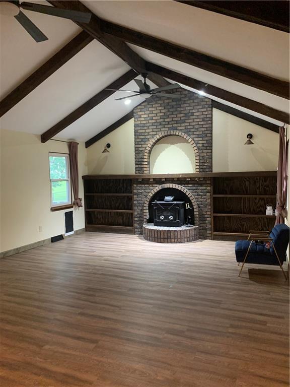 308 NW Shamrock Ave, Lees Summit, MO 64081 - unfurnished living room with a ceiling fan, a brick fireplace, wood finished floors, and baseboards