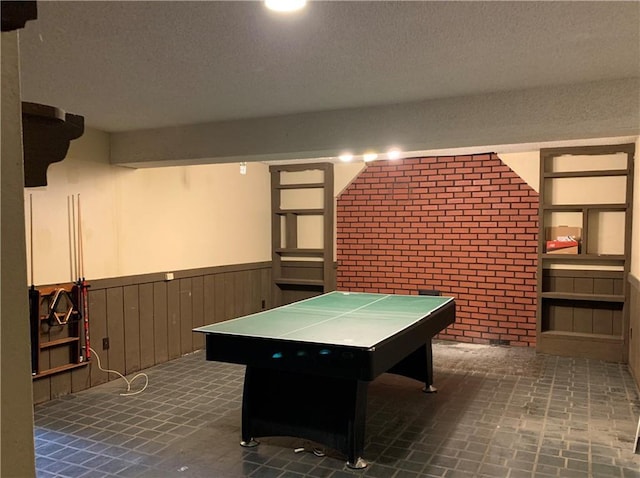 308 NW Shamrock Ave, Lees Summit, MO 64081 - playroom with wainscoting, brick wall, and a textured ceiling