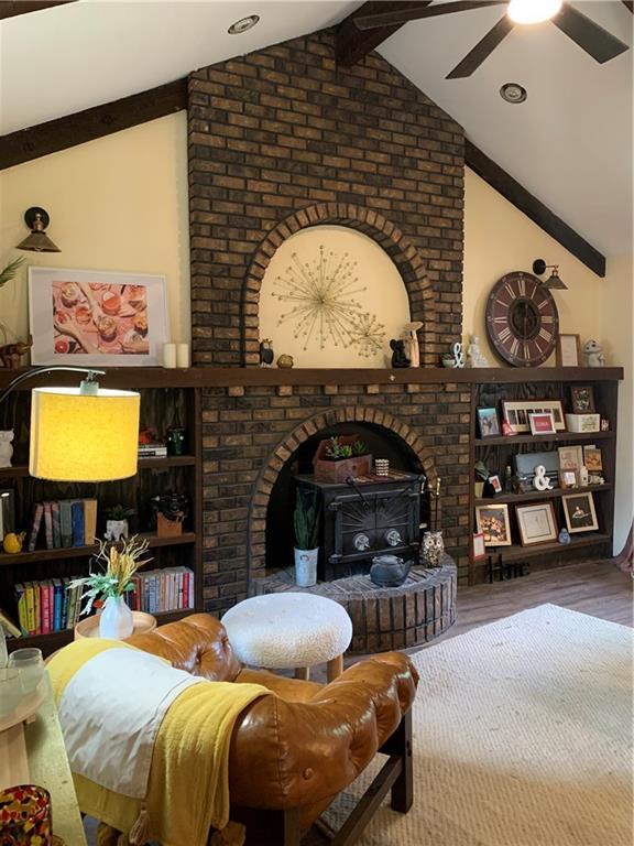 308 NW Shamrock Ave, Lees Summit, MO 64081 - living room with wood finished floors, ceiling fan, and a wood stove
