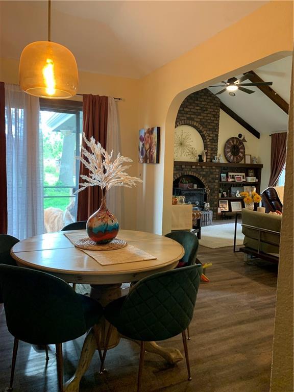 308 NW Shamrock Ave, Lees Summit, MO 64081 - dining space with ceiling fan, a brick fireplace, and wood finished floors