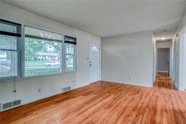 empty room with light wood finished floors and baseboards