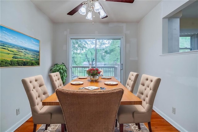 dining space featuring ceiling fan, wood finished floors, and baseboards