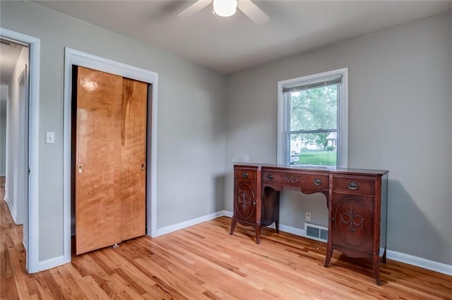 home office with light wood finished floors, ceiling fan, and baseboards