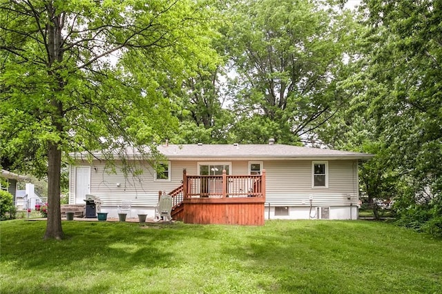 rear view of house with a wooden deck and a lawn