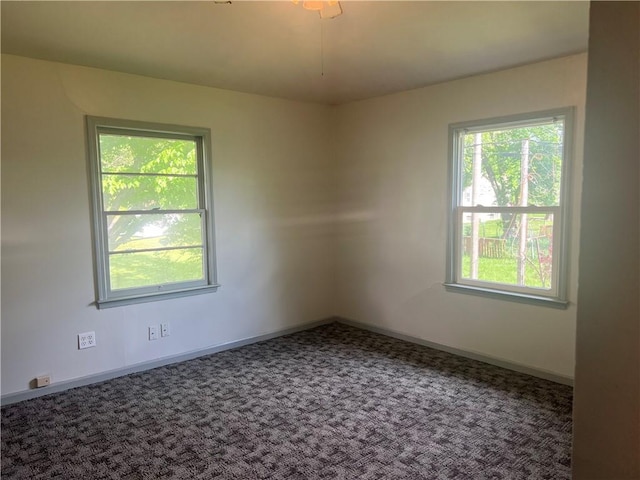 empty room with carpet floors, baseboards, and plenty of natural light