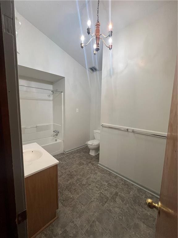 bathroom with an inviting chandelier, vanity, lofted ceiling, toilet, and shower / bathing tub combination