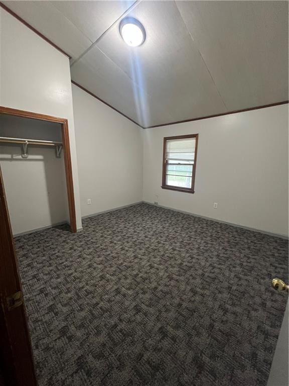 unfurnished bedroom with carpet floors, vaulted ceiling, and a closet